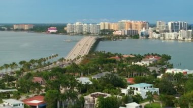 Florida, ABD 'deki Sarasota şehrinde birinci sınıf konutlar. Ufuktaki yüksek binalar ve öndeki yeşil palmiye ağaçları arasındaki liman evleri..