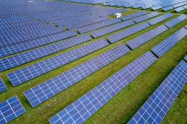 Temiz elektrik enerjisi üretmek için birçok sıra güneş fotovoltaik paneli bulunan sürdürülebilir büyük elektrik santralinin havadan görünüşü. Sıfır emisyon kavramı ile yenilenebilir elektrik.