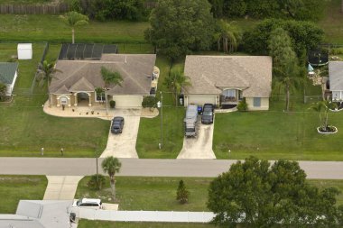 Florida 'nın sakin yerleşim bölgesinde yeşil palmiye ağaçları arasında özel evleri olan küçük bir Amerikan banliyö manzarası..