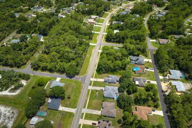 Küçük bir kasabada sokak trafiğinin hava görüntüsü. Florida 'da sakin yerleşim bölgesinde yeşil palmiye ağaçları arasında özel evleri olan Amerikan banliyö manzarası.