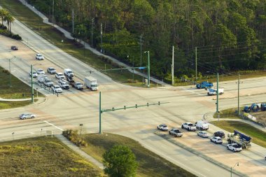 Trafik ışıklarıyla kesişen geniş çok şeritli yolun hava görüntüsü. ABD 'de şehir ulaşımı. Yukarıdan Amerikan şehir trafiği.