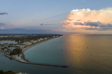 High angle view of crowded Nokomis beach in Sarasota County, USA. Many people enjoing vacations time swimming in ocean water and relaxing on warm Florida sun at sundown.