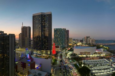 Florida, ABD 'de Miami Brickell şehir merkezinin gece şehir manzarası. Yüksek gökdelen binaları ve modern Amerikan megapolis trafiği olan bir cadde..