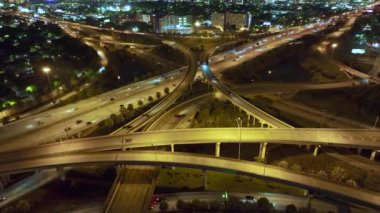 Miami City, Florida 'da gece hızlı giden araba ve kamyonlarla Amerikan otoyolu kavşağının hava görüntüsü. ABD ulaşım altyapısının üstünden görüntüle.