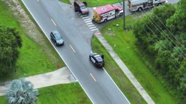 American Caddesi 'ndeki kaza yerine giden acil servis personeli ve araçların hava görüntüsü. ABD 'deki banliyö yolunda araba kazası kurbanlarına ilk yardım ekipleri.