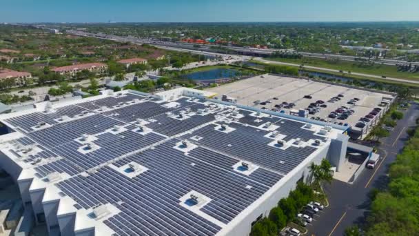緑の生態電力の生産のためのショッピングモール屋上に設置された多くの太陽光発電パネルの空中ビュー 持続可能なエネルギー概念の生産 — ストック動画