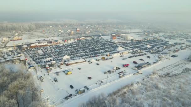 駐車場販売のための多くの車と車のオープン市場のロットの空中ビューや冬に歩く人々 — ストック動画