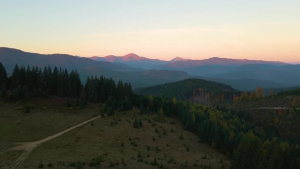 夕焼け時にぼんやりとしたピークと霧の谷と美しいパノラマの山の風景 — ストック動画