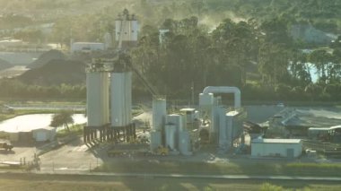 Beton karıştırma fabrikası endüstriyel alanda çimento kamyonları ve ağır inşaat ekipmanları ile.