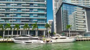 Miami City şehir merkezinde Miami Nehri 'nde, Florida, ABD' deki beton ve cam gökdelen binaları arasında lüks yatları olan bir şehir. Modern Amerikan megapolis kentsel manzarası.