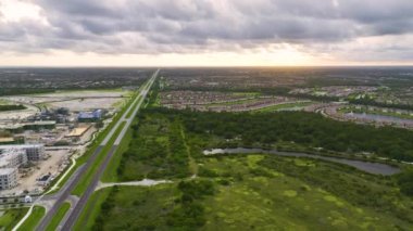 İnşaat halindeki yerel ulaşım arterine yakın apartmanların bitmemiş çerçevelerinin havadan görüntüsü. Amerikan banliyölerinde konut geliştirme. ABD 'de emlak piyasası.
