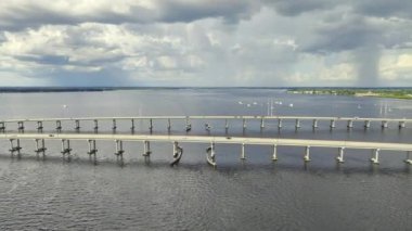 Aerial view of Barron Collier Bridge and Gilchrist Bridge in Florida with moving traffic. Transportation infrastructure in Charlotte County connecting Punta Gorda and Port Charlotte over Peace River.