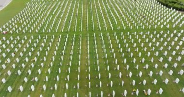 Sarasota Ulusal Mezarlığı 'nda yeşil çimlerin üzerinde bir sürü beyaz mezar taşı var. Anma Günü konsepti.