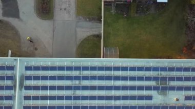 Ticari alışveriş merkezinin çatısına yeşil ekolojik elektrik üretmek için monte edilmiş mavi fotovoltaik panelleri olan güneş enerjisi santrali. Sürdürülebilir enerji konsepti üretimi.