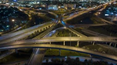 Gece Miami, Florida 'da, hızlı hareket eden araçlar ve kamyonlarla Amerikan otobanının kavşağından bir görüntü. ABD ulaşım altyapısının zaman kaydı.