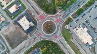 American City caddesindeki kavşağın yukarısından hareket eden trafik arabalarının görüntüsü. Kentsel dairesel ulaşım kavşağı.