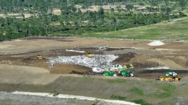 Atık yönetimi konsepti. Yeraltına çöp gömen buldozerlerle dolu büyük bir arazi. Modern tüketiciliğin çevre üzerindeki zararlı etkisi.