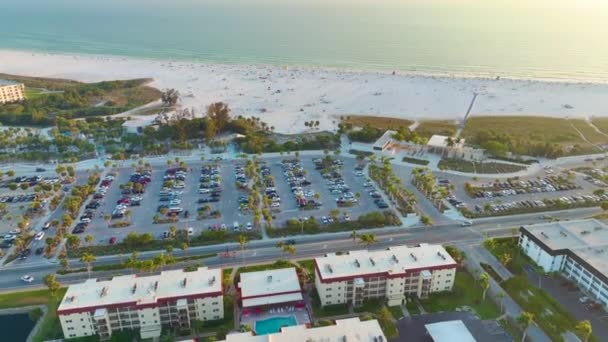 米国サラソータの白い砂浜とシエスタキービーチでの観光車の駐車場付きのビーチフロントのレンタルアパートの上からの眺め 暖かいフロリダ州で人気の休暇スポット — ストック動画