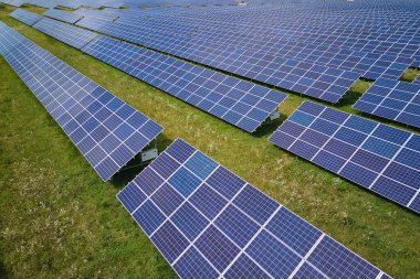 Temiz elektrik enerjisi üretmek için sıra sıra güneş fotovoltaik panelleri olan sürdürülebilir büyük elektrik santralinin havadan görünüşü. Sıfır emisyonlu yenilenebilir elektrik kavramı.