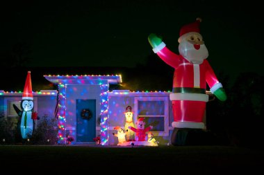 Florida aile evinin ön bahçesinde parlak ışıklandırılmış noel süslemeleri. Kış tatili için dışarıda dekor.