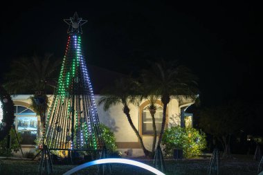 Florida aile evinin ön bahçesinde parlak ışıklandırılmış noel süslemeleri. Kış tatili için dışarıda dekor.