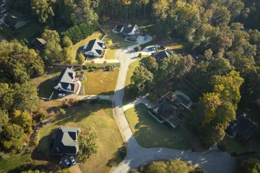 Güney Carolina 'nın banliyölerindeki sarı sonbahar ağaçları arasındaki pahalı konutların manzarası. Amerikan banliyölerinde emlak gelişimine örnek olarak Amerikan rüya evleri.