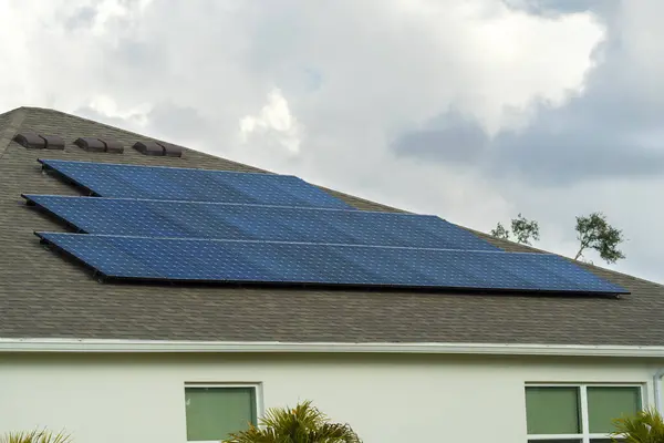 郊外の農村部できれいな生態系電気の生産のための太陽光パネルで覆われた屋根を持つ米国の普通の住宅 省エネのための自立住宅への投資の概念 — ストック写真