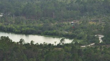 Florida orman ormanlarında yangın söndürmek için havadan su dolduran itfaiye helikopterinin görüntüsü. Acil servis helikopteri ormanda yangın çıkarmaya çalışıyor..