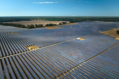 Temiz elektrik enerjisi üretmek için sıra sıra güneş fotovoltaik panelleri olan sürdürülebilir büyük elektrik santralinin havadan görünüşü. Sıfır emisyonlu yenilenebilir elektrik kavramı.