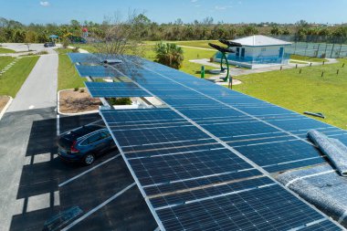 Park alanının gölgesine kurulmuş kasırga rüzgârlı güneş panelleri tarafından, temiz enerji üretimi için park edilmiş arabalar için tahrip edildi. Şiddetli hava şartlarının Florida altyapısına zararı.