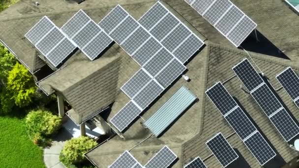 きれいな生態系の電気エネルギーを生成するための青い太陽光発電パネルと典型的なアメリカの建物の屋根の空中ビュー 退職所得の概念のための再生可能エネルギーへの投資 — ストック動画