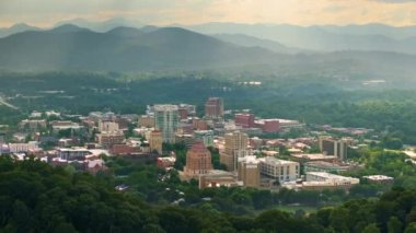 ABD 'nin seyahat rotasının havadan görüntüsü. Kuzey Carolina 'daki Asheville şehrinde günbatımında yüksek şehir binaları ve Appalachian dağ tepeleri var..