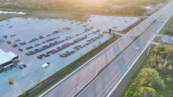 高速道路の道端で販売のために駐車多くの真新しい車と地元のディーラーの大規模な駐車場 アメリカの自動車産業の発展と製造車の概念の流通 — ストック動画