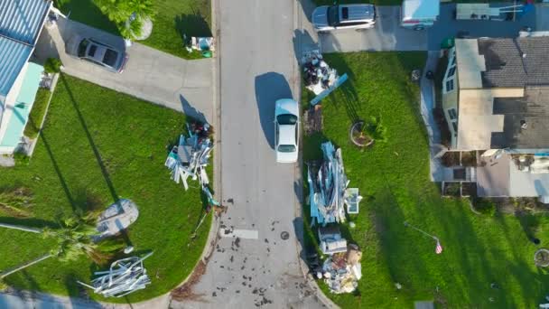 フロリダ州のモバイルホーム住宅地でハリケーンイアンの後に深刻な被害を受けた家から通り側のごみの山 自然災害の結果 — ストック動画