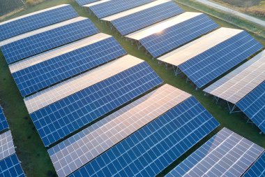 Temiz ekolojik elektrik enerjisi üretmek için sıra sıra güneş fotovoltaik panelleri olan sürdürülebilir büyük elektrik santralinin havadan görünüşü. Sıfır emisyon kavramı ile yenilenebilir elektrik