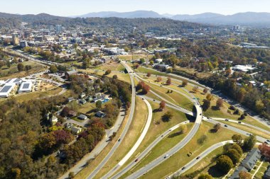 American freeway intersection in Asheville, North Carolina with fast driving cars and trucks in autumnal season. View from above of USA transportation infrastructure.
