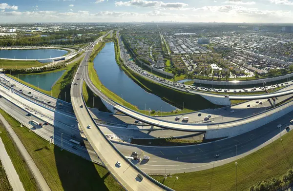 Aerial view of american freeway intersection with fast driving cars and trucks in Miami, Florida. View from above of USA transportation infrastructure.