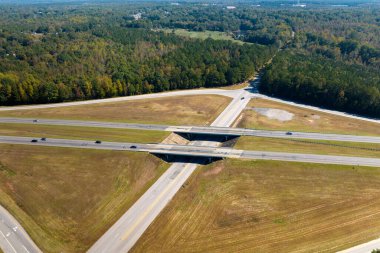 Elevated view of freeway exit junction over road lanes with fast moving traffic cars and trucks. Interstate transportation infrastructure in USA.