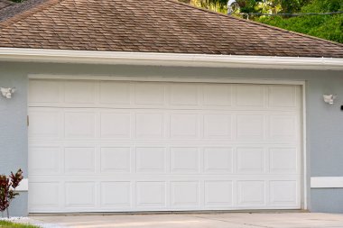 Geniş garaj, çift kapı ve modern Amerikan evinin beton yolu..