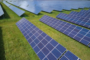 Temiz elektrik enerjisi üretmek için sıra sıra güneş fotovoltaik panelleri olan sürdürülebilir büyük elektrik santralinin havadan görünüşü. Sıfır emisyonlu yenilenebilir elektrik kavramı.