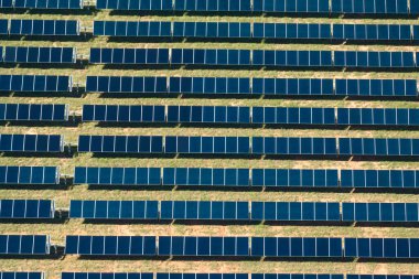 Temiz elektrik enerjisi üretmek için sıra sıra güneş fotovoltaik panelleri olan sürdürülebilir büyük elektrik santralinin havadan görünüşü. Sıfır emisyonlu yenilenebilir elektrik kavramı.