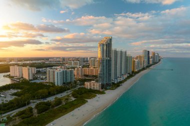 Günbatımında Atlantik Okyanusu kıyısında lüks oteller ve konutlarla Sunny Isles Beach 'in hava manzarası. Güney Florida 'daki Amerikan turizm altyapısı.