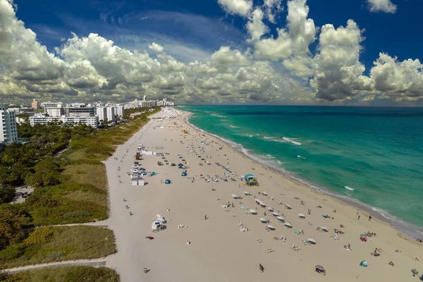 Güney Sahili 'nin kumlu yüzeyi. Sıcak Florida güneşinde dinlenen turistler. Güney Amerika 'da turizm altyapısı. Yüksek lüks otelleri ve apartmanları olan Miami Beach City..