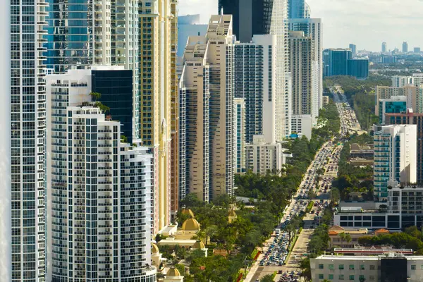 Sunny Isles Sahili 'nin havadan manzarası kalabalık sokak trafiği lüks oteller ve Atlantik Okyanusu kıyısındaki apartmanlar. Güney Florida 'daki Amerikan turizm altyapısı.