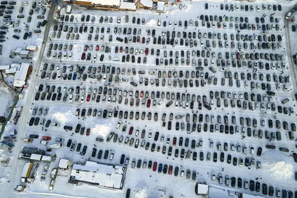 Aerial view of vehicle open market lot with many cars for sale parked and people customers walking in winter.