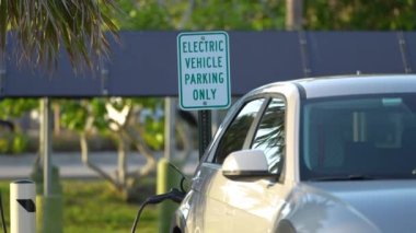 Şehrin caddesinde park halindeki güneş enerjisi yenilenebilir enerji kaynağından elektrik yüklü bir elektrik prizi..