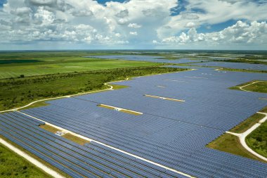 Temiz elektrik enerjisi üretmek için birçok sıra güneş fotovoltaik paneli bulunan sürdürülebilir büyük elektrik santralinin havadan görünüşü. Sıfır emisyon kavramı ile yenilenebilir elektrik.