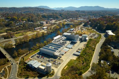 Sanayi binasının çatısına yeşil ekolojik elektrik üretmek için monte edilen mavi fotovoltaik güneş panellerinin hava görüntüsü. Sürdürülebilir enerji konsepti üretimi.