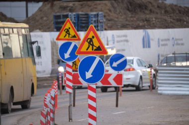 Yol çalışmaları trafik işaretlerini uyardı. Şehir caddesinde inşaat çalışması ve yavaş hareket eden arabalar..