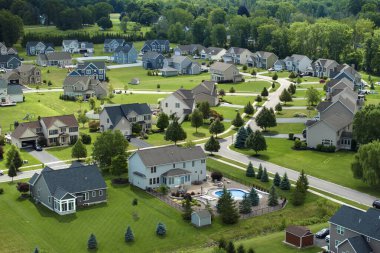 Yaz mevsiminde büyük arka bahçeleri ve yeşil çimenleri olan lüks banliyö evleri. Rochester, New York 'ta kırsal kesimde özel yerleşim evleri..
